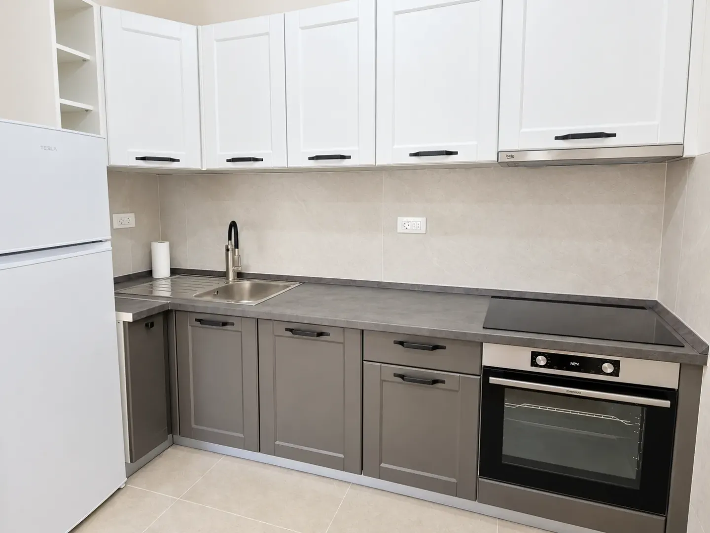 Kitchen with gray and white cabinets, a sink, and a built-in oven.