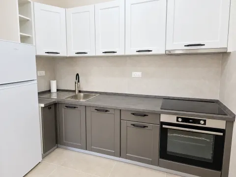 Kitchen with gray and white cabinets, a sink, and a built-in oven. - image 5