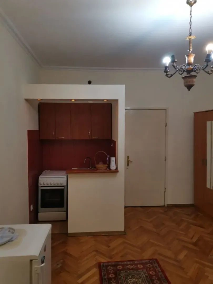 Small functional kitchen with wooden cabinets and a stove.