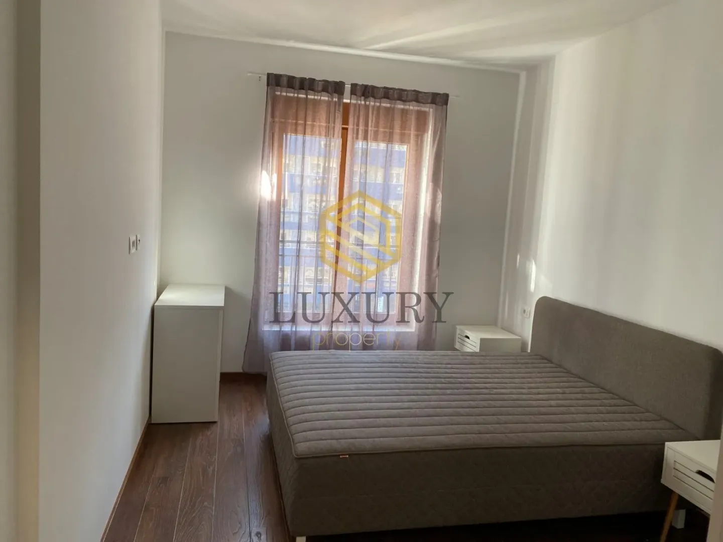 Bright bedroom with a double bed and a window.
