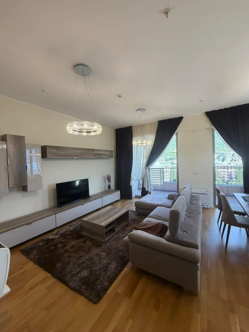 Spacious living room with a sofa set, TV unit, and terrace access.