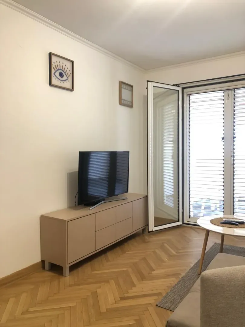 Living room with a TV, credenza, and access to the terrace.