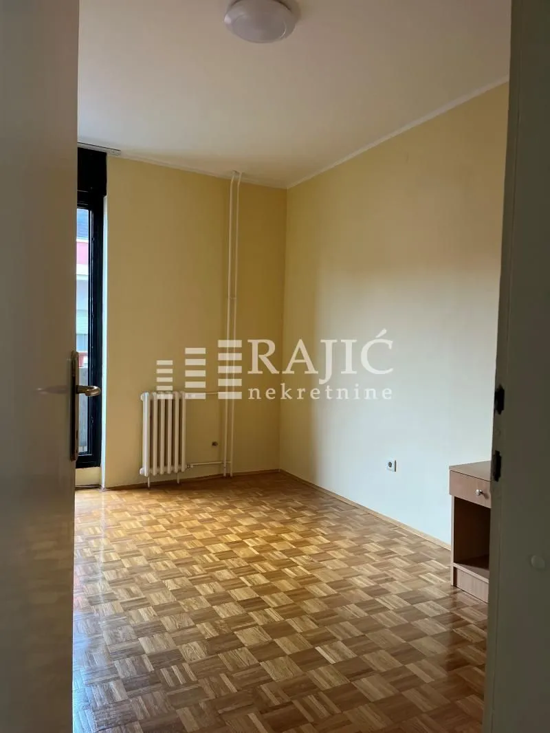 Empty room with parquet flooring and yellow walls.