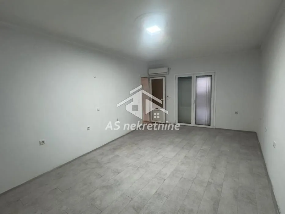Empty room with white walls, tiled floor, and access to a terrace.
