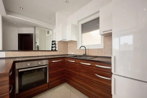 Modern kitchen with wooden cabinets and a built-in oven. - image 6