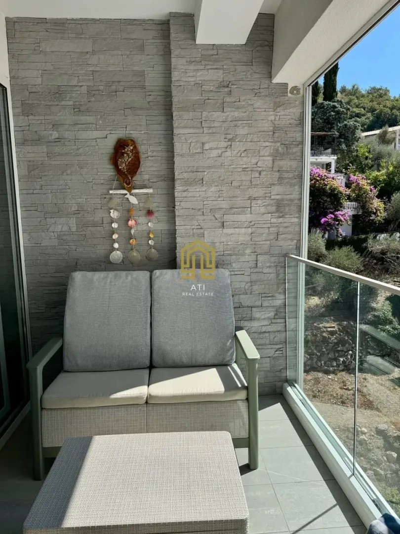 Furnished terrace with seating furniture and a view of greenery.