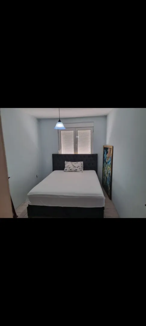 A simply furnished bedroom with a double bed.