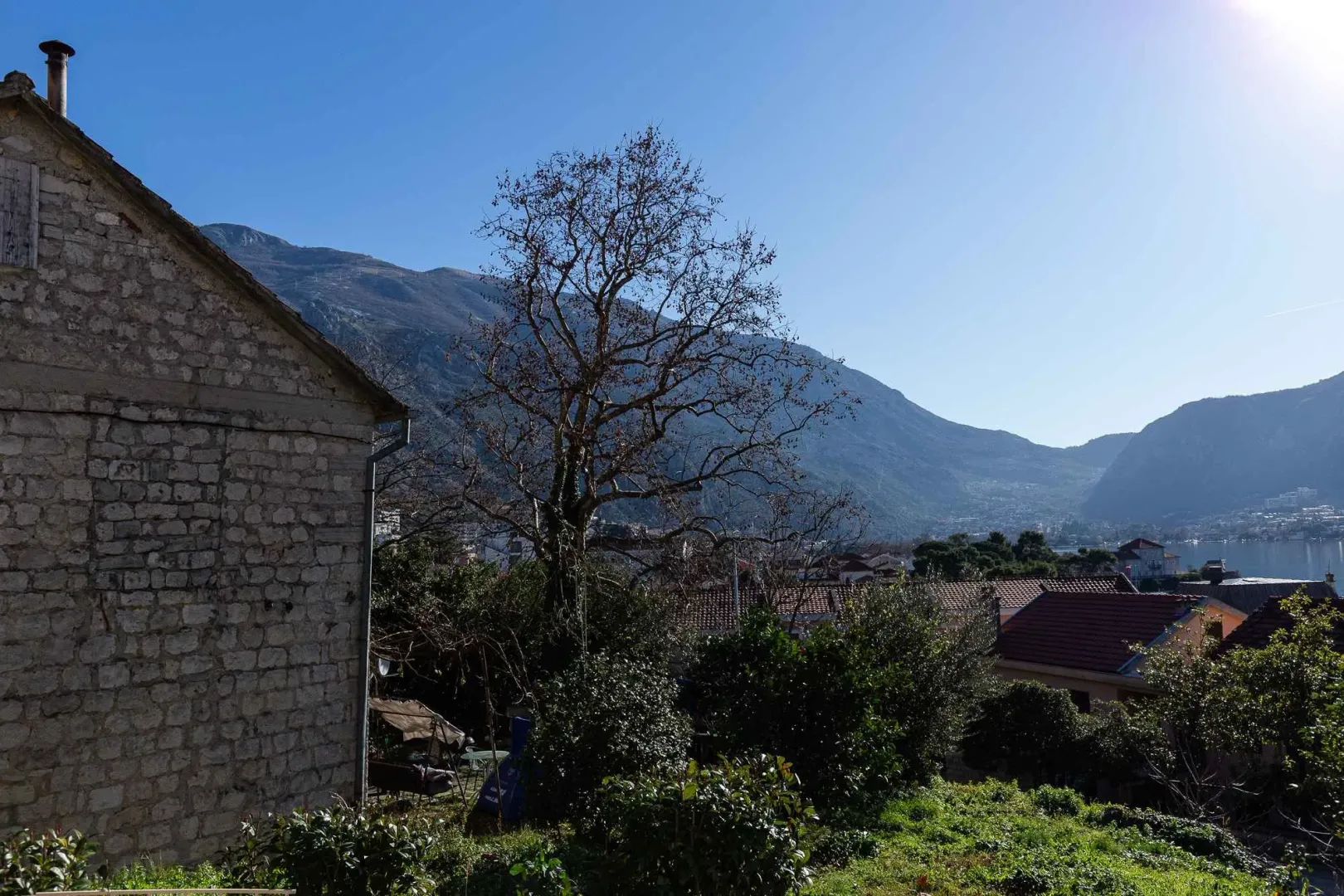 Pogled na dvorište i okolne planine sa tradicionalne kamene kuće.
