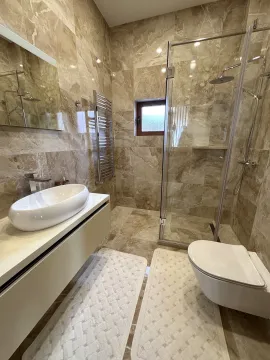 Modern marble-tiled bathroom featuring a walk-in shower and a vessel sink. - image 4