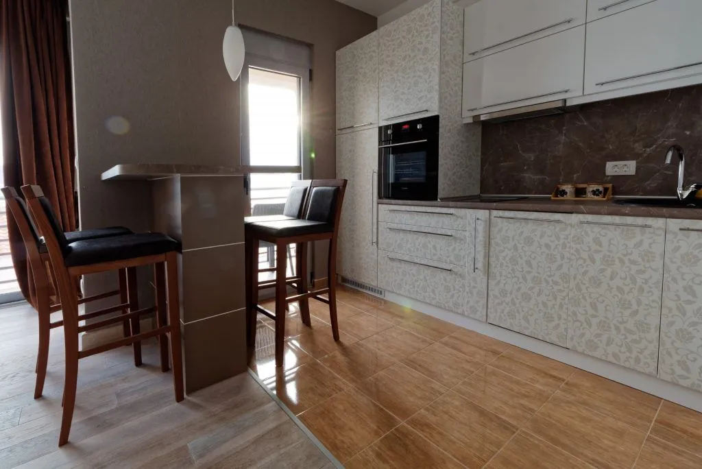 Modern kitchen with a breakfast bar and dining chairs.