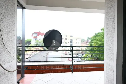 View from the tiled balcony overlooking surrounding buildings and parking. - image 12