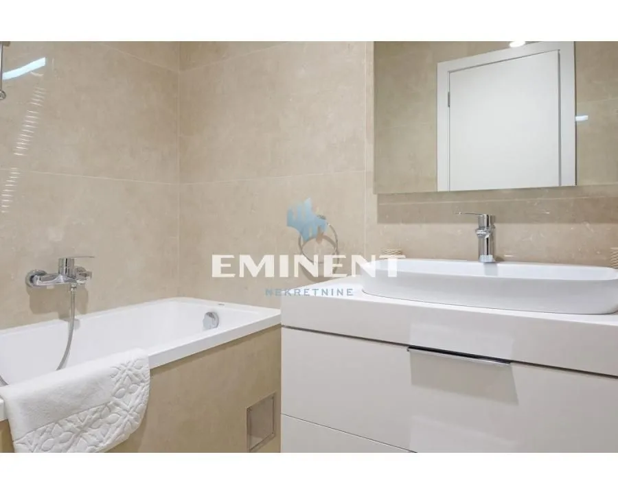 Modern bathroom equipped with a bathtub, washbasin, and mirror.