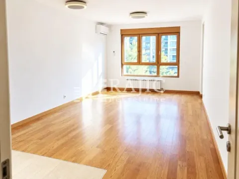 Empty living room with parquet flooring and a large window. - image 3