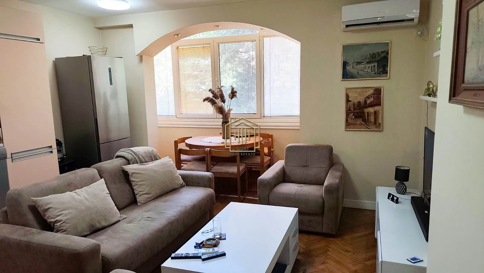 Living room with a sofa, armchair and a dining table near the window.