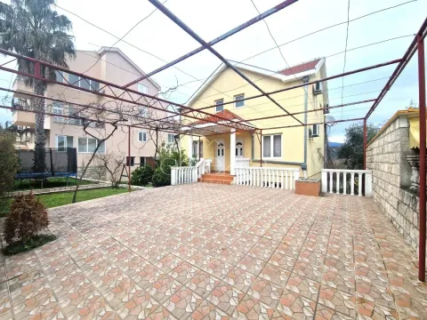 Popločano dvorište sa nadstrešnicom i pogledom na kuću. - image 4