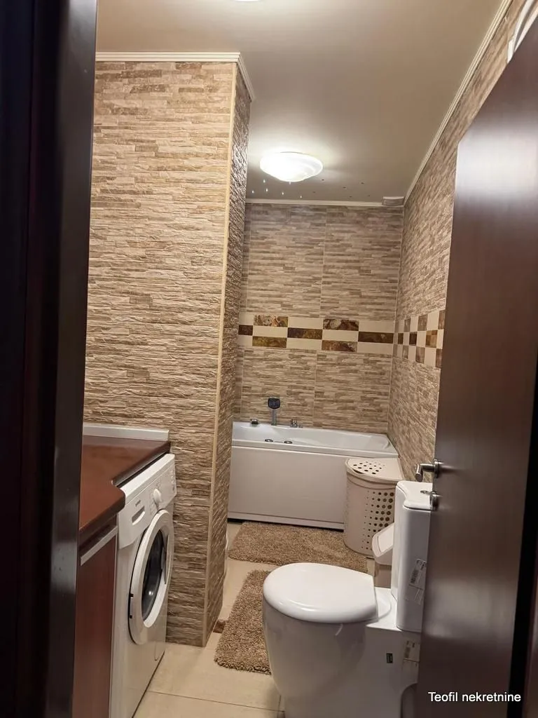Kupatilo opremljeno sanitarijama, kadom i veš mašinom.