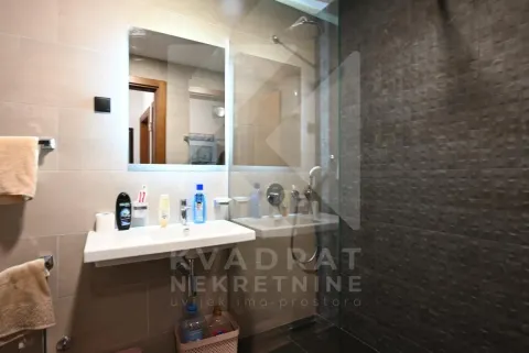 Moderne kupatilo sa umivaonikom, ogledalom i tuš kabinom sa staklenom pregradom. - image 10