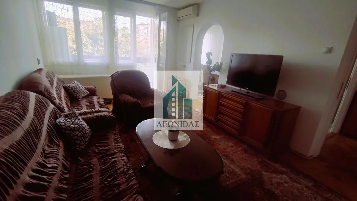 Living room with a sofa set, coffee table, and TV on a dresser.
