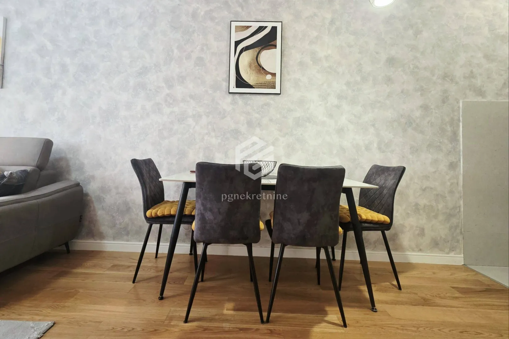 Dining table with chairs against a decorated wall in the living room.