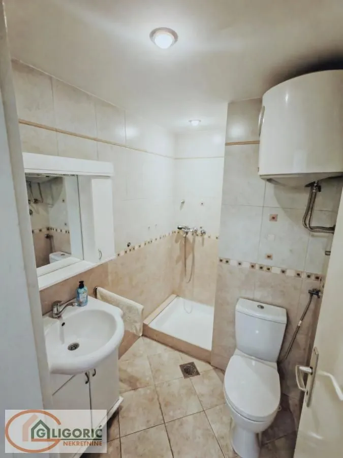Manje kupatilo sa tuš kabinom, umivaonikom i wc šoljom.