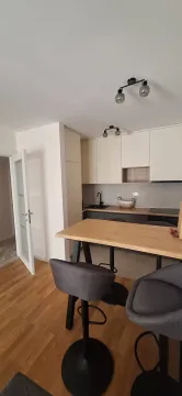 Modern kitchen with a breakfast bar and dining table. - image 3