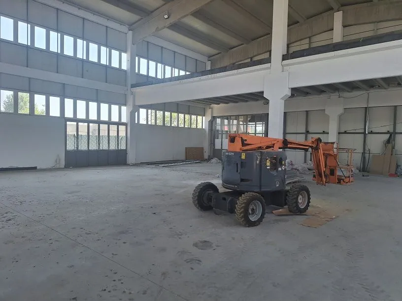 Large industrial space under construction with a lift machine.