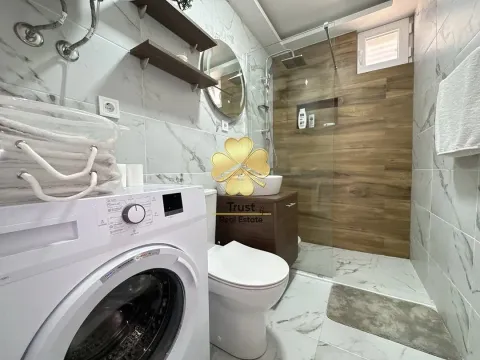 Modernly equipped bathroom with a walk-in shower and washing machine. - image 12