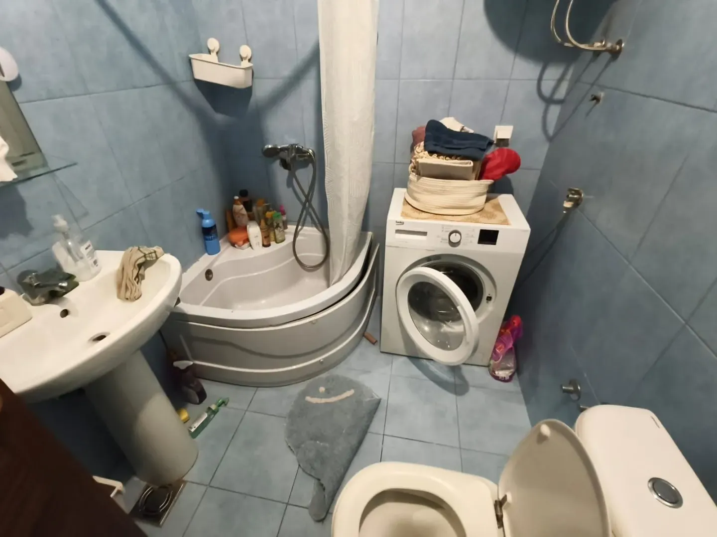 Kupatilo sa tuš kadom, umivaonikom, WC šoljom i veš mašinom.
