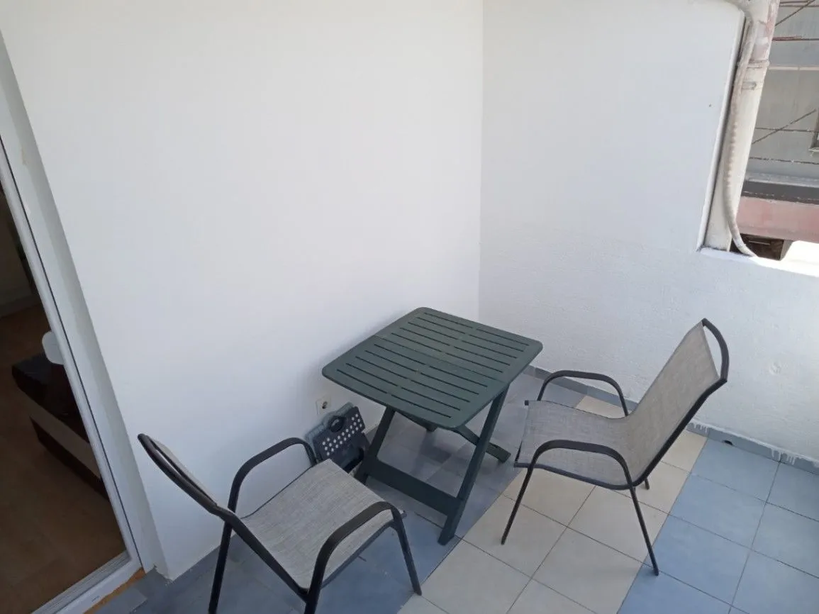 Small terrace furnished with a small table and two chairs.