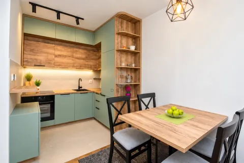Modern kitchen with wood and green elements combined with a dining table. - image 8