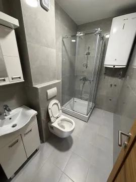 Moderne opremljeno kupatilo sa tuš kabinom i keramičkim pločicama u sivim tonovima. - image 7