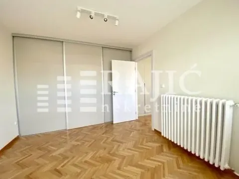 Empty room with parquet flooring, built-in wardrobe, and radiator. - image 12