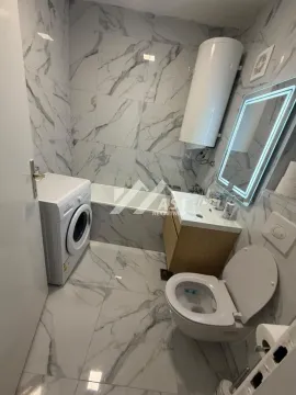 Moderno kupatilo opremljeno tuš kabinom, umivaonikom, WC šoljom i veš mašinom. - image 9