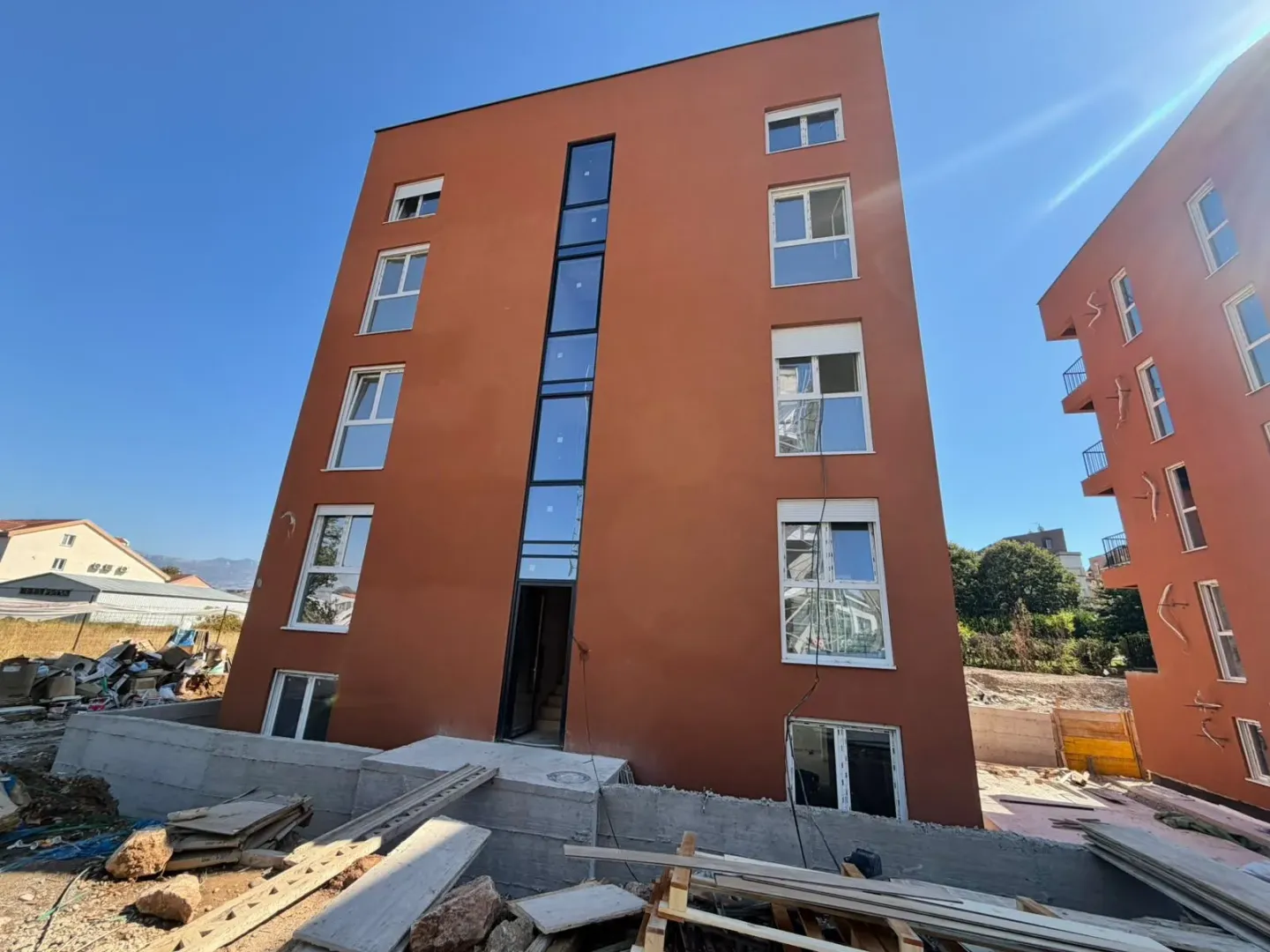 Spoljašnji izgled stambene zgrade sa fasadom i prozorima.