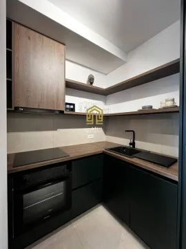 Moderna kuhinja sa tamnim elementima i drvenim detaljima. - image 7
