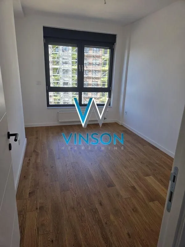 Empty room with wooden flooring and a window.
