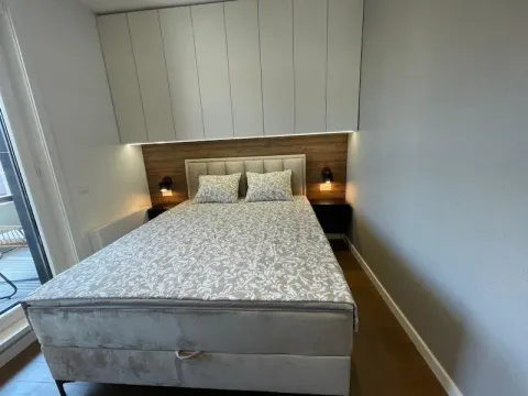 Furnished bedroom with a double bed and built-in units above the headboard. - image 13