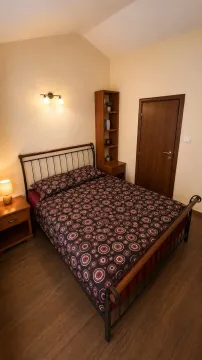 Namještena spavaća soba sa bračnim krevetom, drvenim ormarom i noćnim stočićima. - image 11