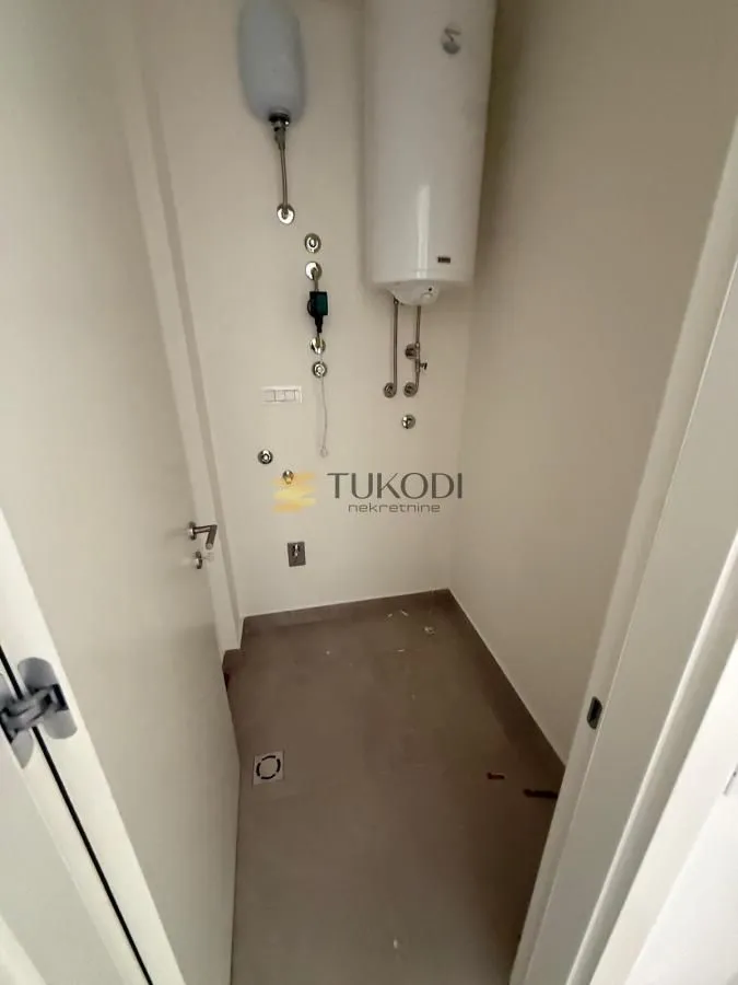 Manje kupatilo sa instalacijama i bojlerom u fazi renoviranja.