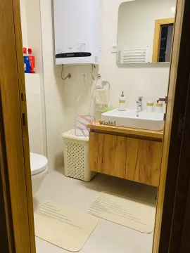 View of a modern bathroom equipped with a washbasin, toilet, and water heater. - image 11