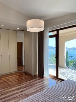 Bedroom with a double bed, built-in wardrobe, and access to a terrace with a sea view. - image 11