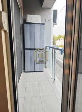 Uska popločana terasa sa ormarom za odlaganje i staklenom ogradom. - image 6