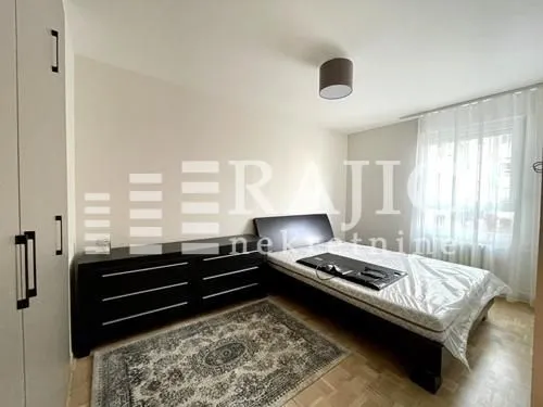 Furnished bedroom with a bed and wardrobe.