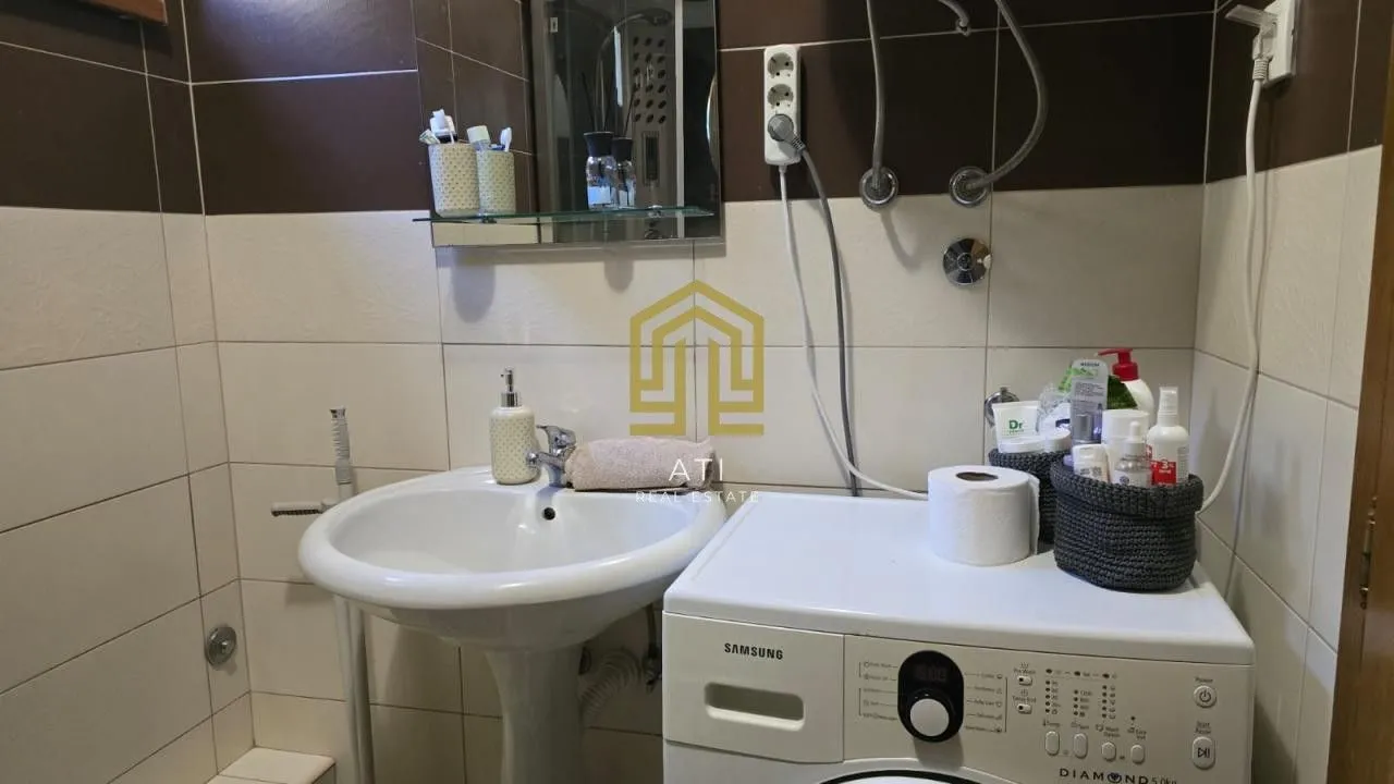 Manje kupatilo sa umivaonikom i veš mašinom.