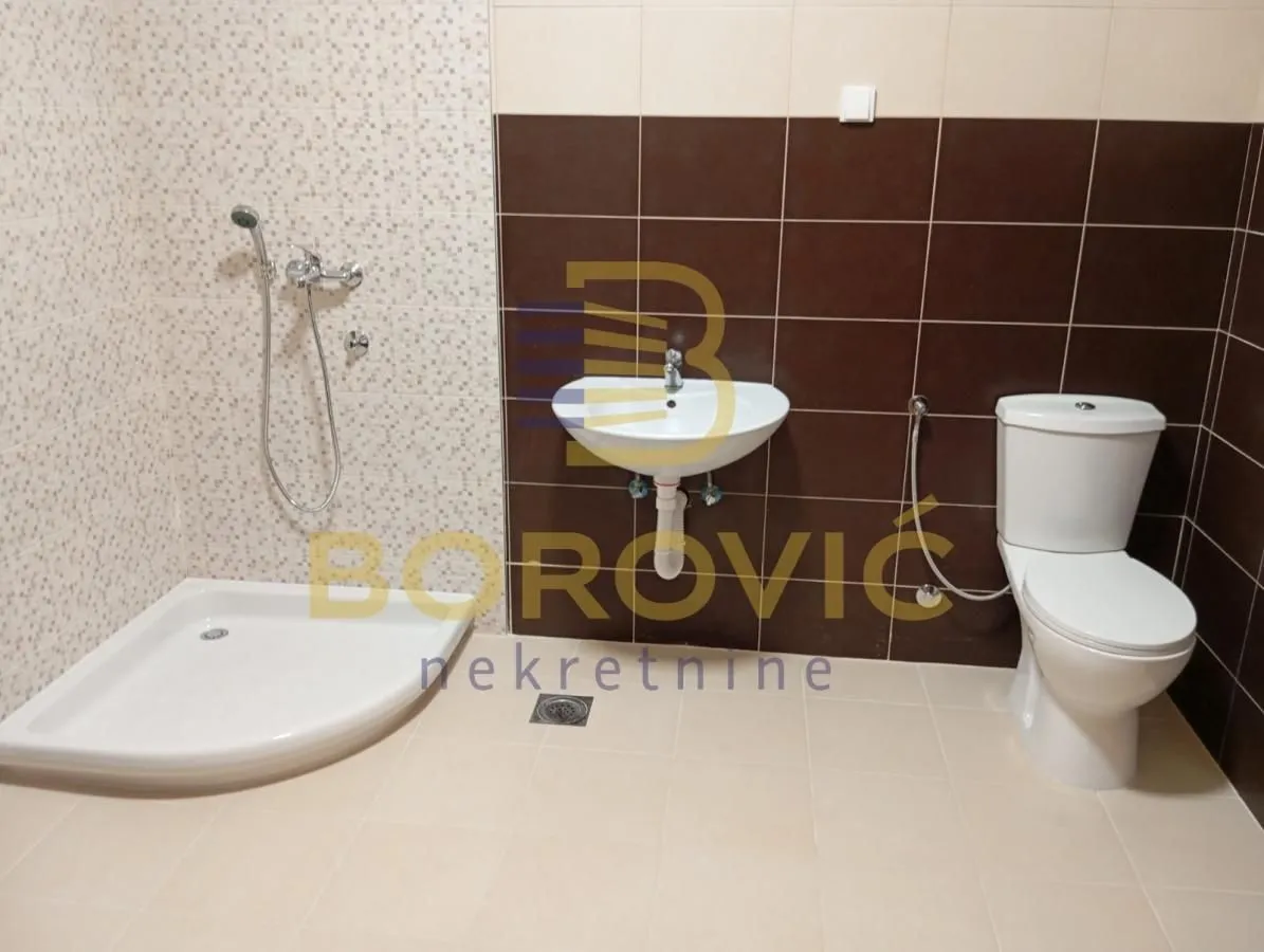 Bathroom equipped with a shower cabin, washbasin, and toilet.