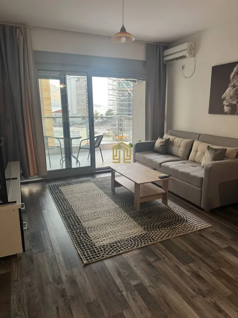 Living room with a sofa, coffee table, and balcony access.