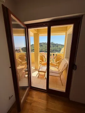 Pogled kroz balkonska vrata na terasu sa garniturom za sjedenje. - image 16