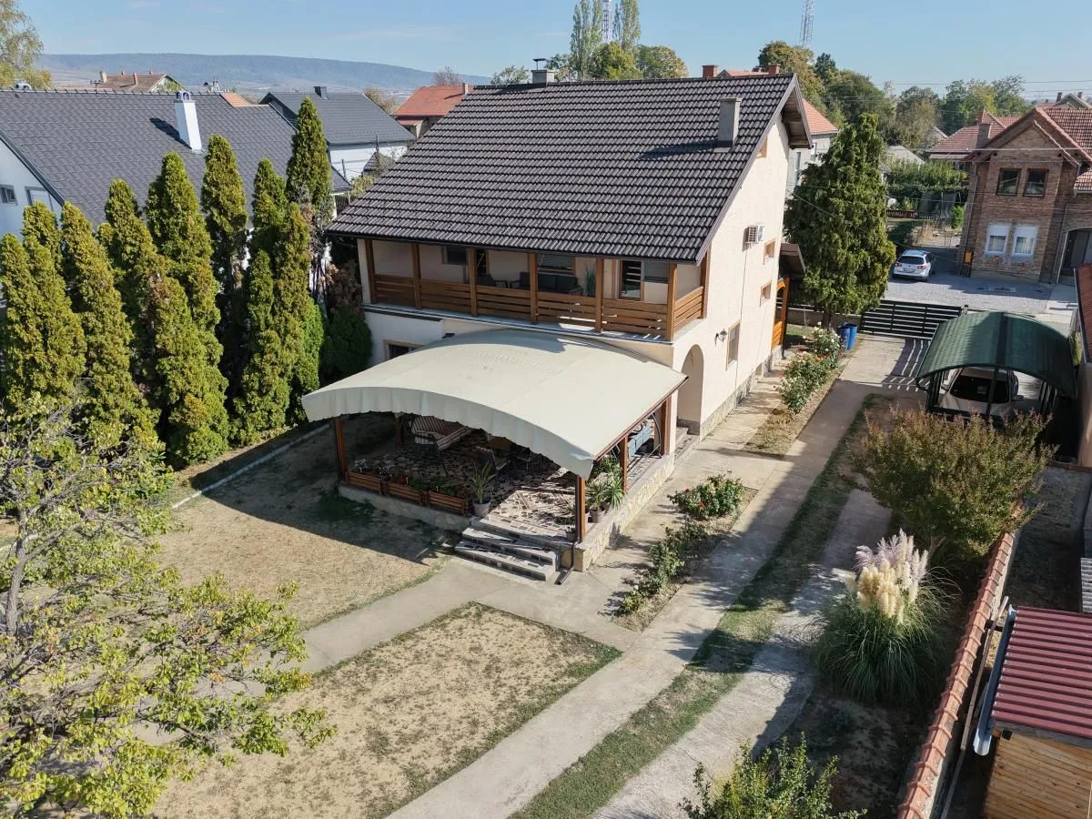 Pogled iz vazduha na kuću sa uređenim dvorištem, terasom i zelenilom.