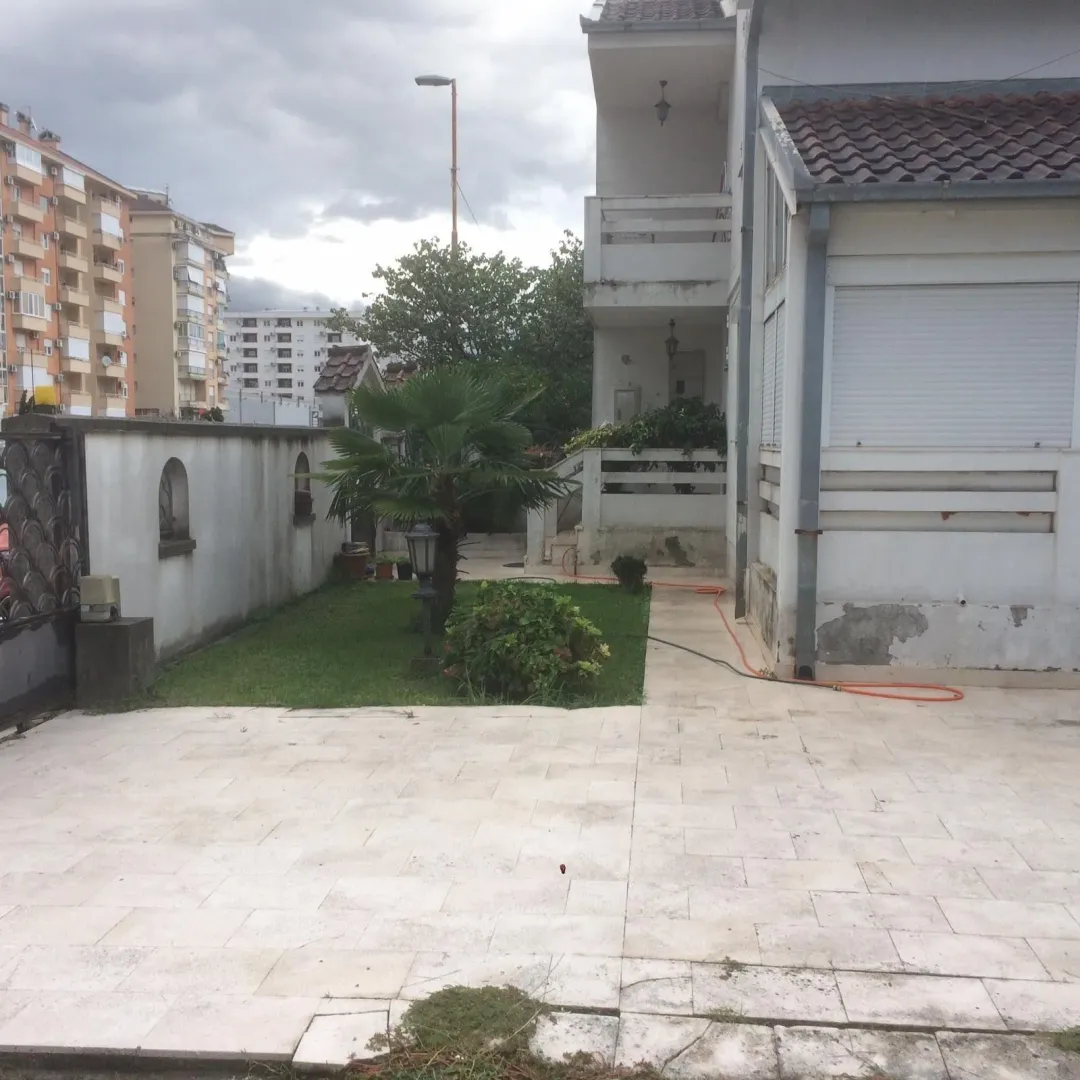 The courtyard of the house with a paved area and a small lawn.
