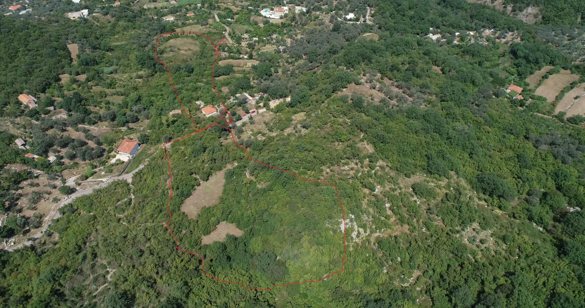 Zračni snimak zemljišta sa označenim crvenim granicama.
